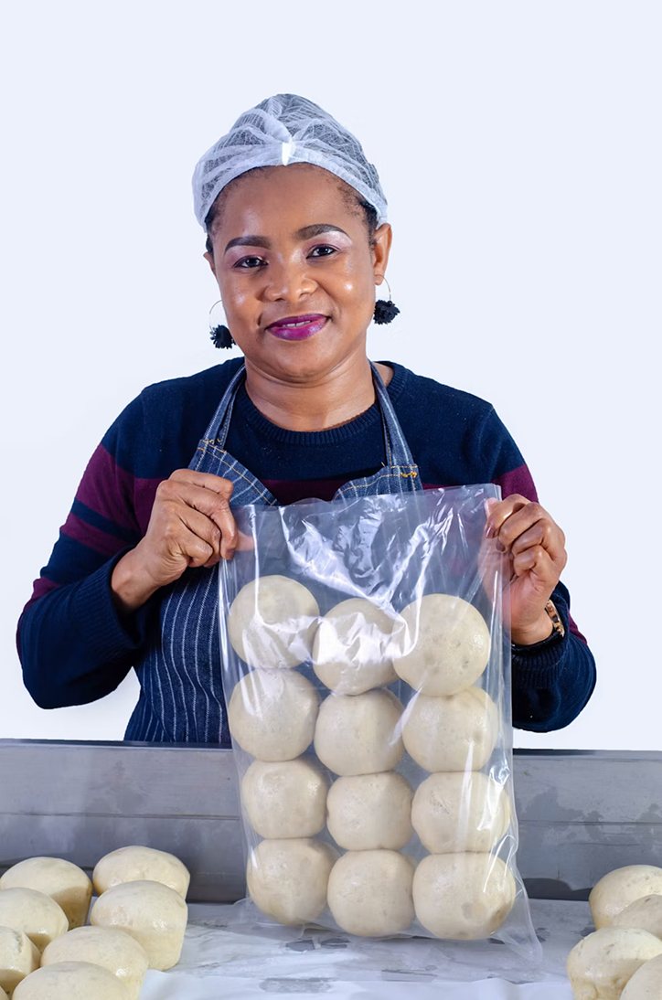 A baker holding up a bag of fresh dough